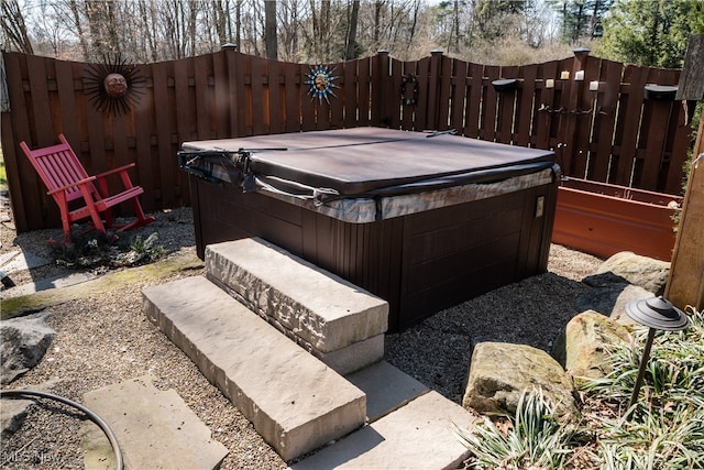 view of yard with fence and a hot tub