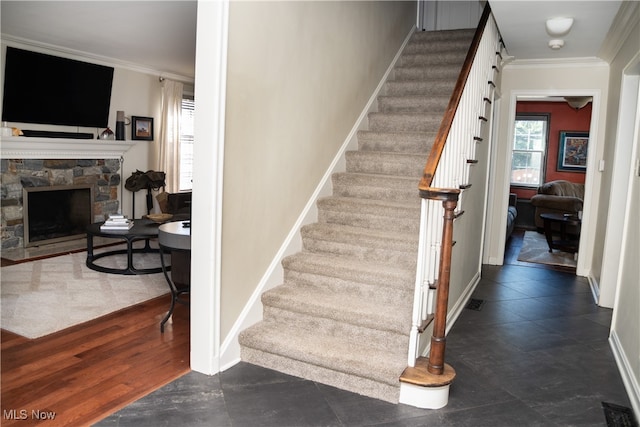 staircase with a fireplace, baseboards, and ornamental molding