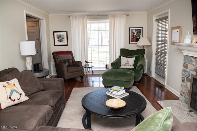 living room with a wealth of natural light, a stone fireplace, and ornamental molding