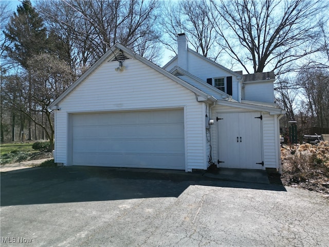 view of front facade with a chimney and an attached garage