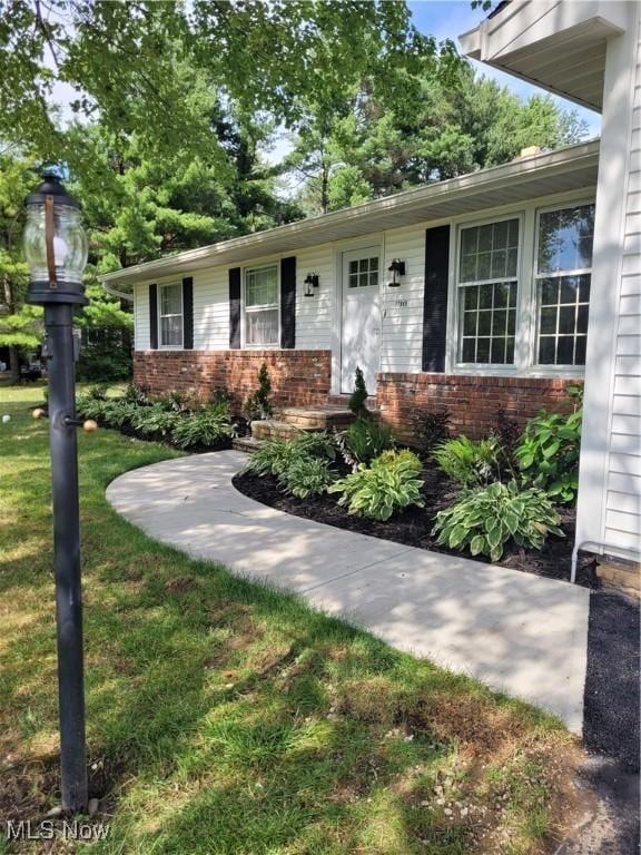 view of front facade with a front yard and brick siding