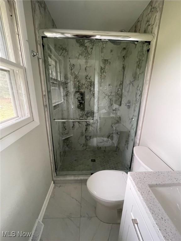 full bathroom with a marble finish shower, toilet, marble finish floor, and vanity