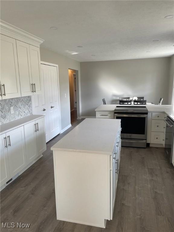 kitchen with white cabinets, stainless steel electric range, dark wood-style flooring, and a center island