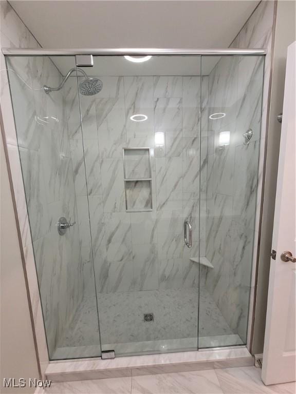 bathroom with marble finish floor and a marble finish shower