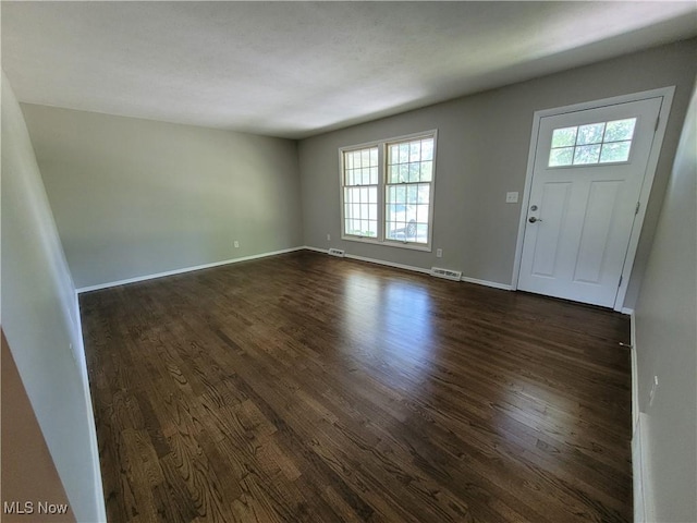 entrance foyer featuring dark wood-style floors, visible vents, and baseboards