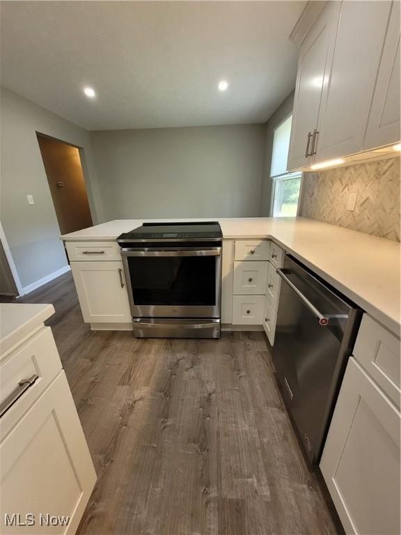 kitchen with stainless steel appliances, dark wood-type flooring, light countertops, and white cabinetry