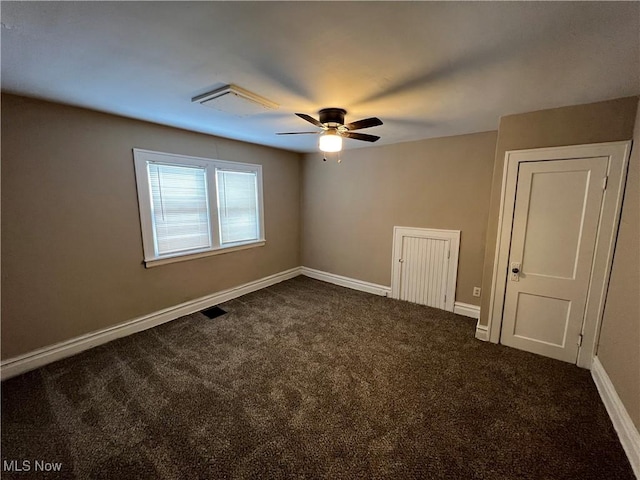 unfurnished room featuring dark colored carpet, visible vents, baseboards, and a ceiling fan