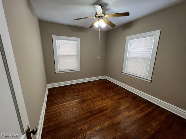 unfurnished room featuring baseboards, ceiling fan, and dark wood-style flooring