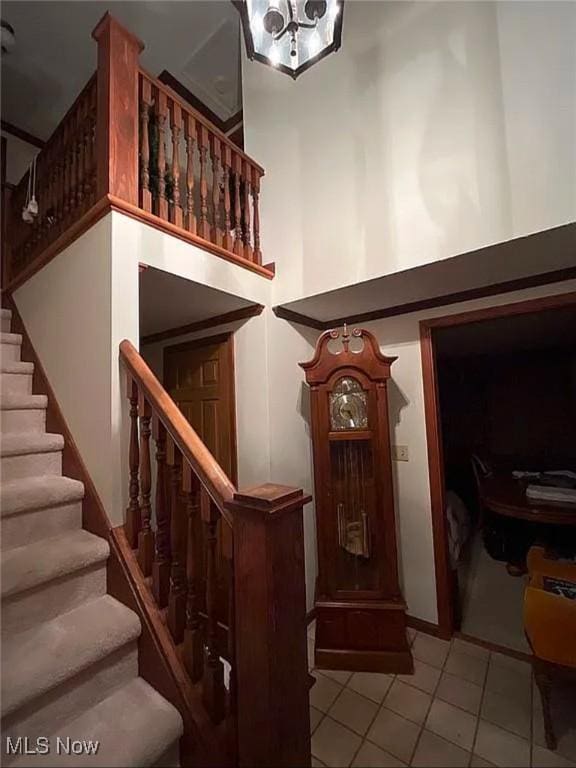 staircase featuring tile patterned floors and a towering ceiling