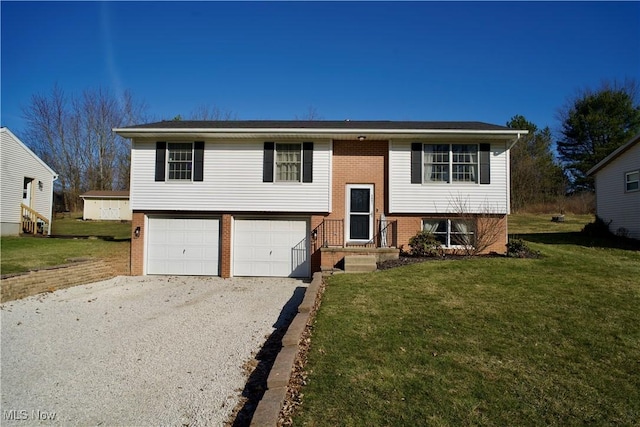 bi-level home with a front yard, an attached garage, brick siding, and driveway