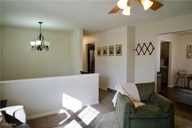 sitting room with visible vents, baseboards, and ceiling fan with notable chandelier