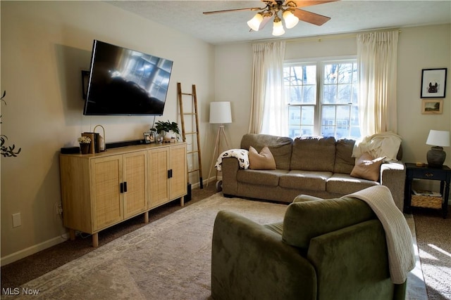 living room featuring baseboards, carpet, and a ceiling fan