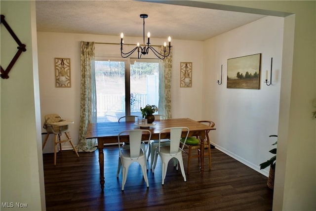 dining room with dark wood finished floors, a chandelier, a textured ceiling, and baseboards