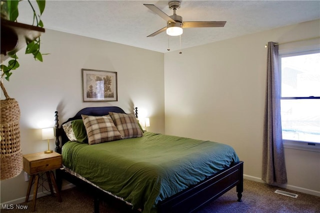 bedroom featuring visible vents, a textured ceiling, carpet floors, baseboards, and ceiling fan