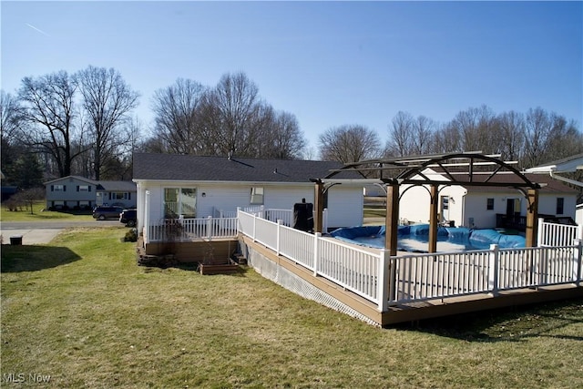 back of house featuring a fenced in pool, a lawn, a deck, and a pergola