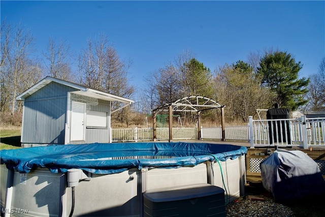 view of pool with a fenced in pool, fence, a shed, an outdoor structure, and area for grilling