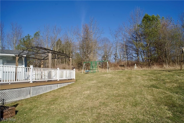 view of yard with a playground and a deck