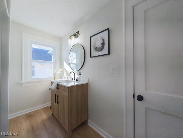 bathroom with vanity, wood finished floors, and baseboards