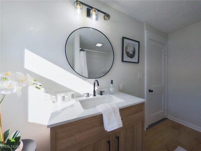 full bathroom featuring wood finished floors and vanity