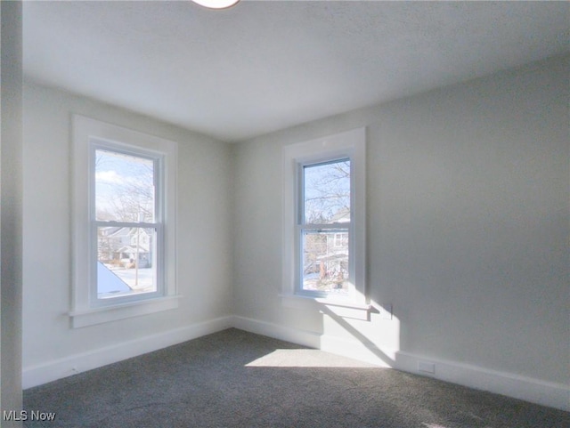 carpeted spare room with baseboards