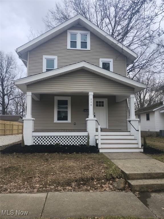 american foursquare style home with central AC unit and covered porch