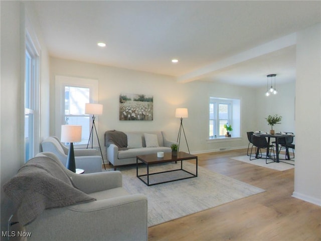 living room with recessed lighting, beamed ceiling, baseboards, and wood finished floors