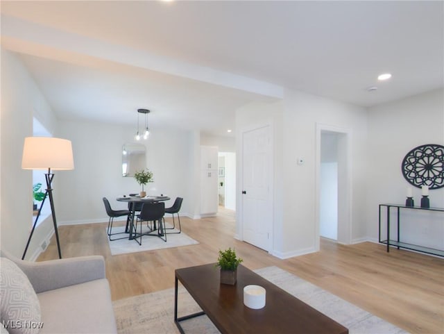 living room featuring recessed lighting, baseboards, and light wood-style floors