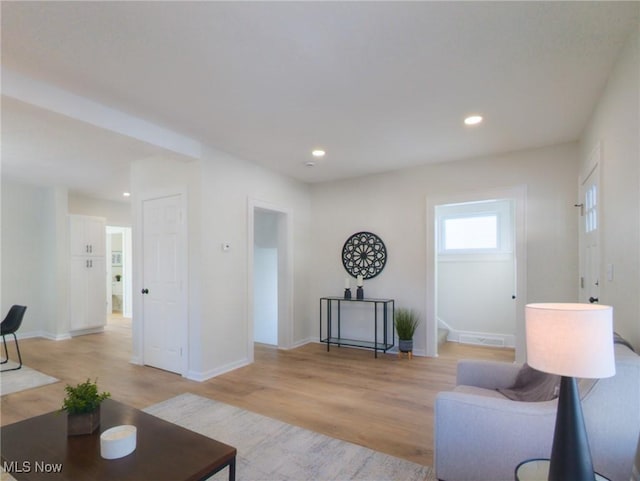 living room with recessed lighting, baseboards, and light wood finished floors