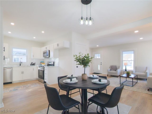 dining room with plenty of natural light, recessed lighting, and light wood-type flooring