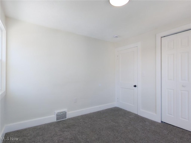 unfurnished bedroom with carpet, visible vents, a closet, and baseboards