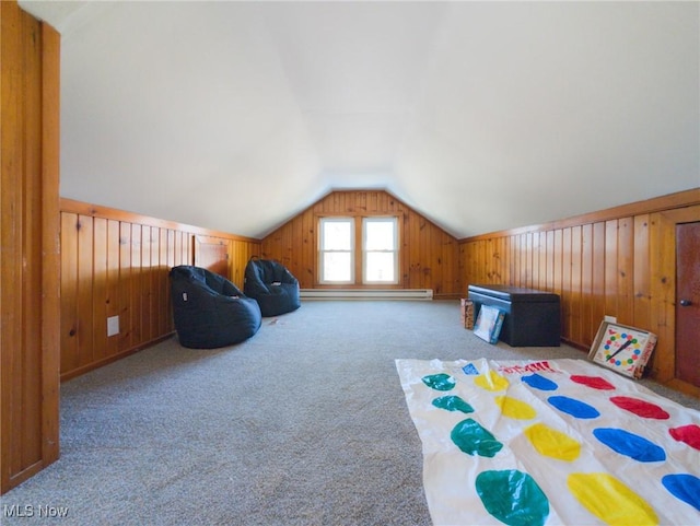 recreation room featuring lofted ceiling, carpet flooring, wood walls, and a baseboard radiator