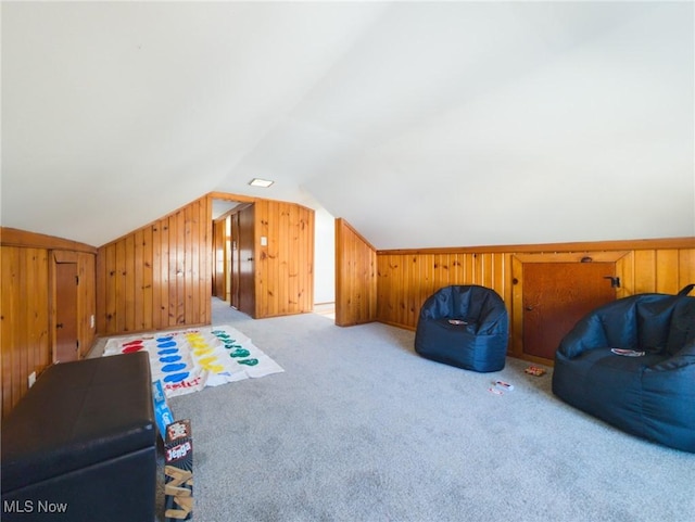 bonus room featuring wooden walls, carpet floors, and vaulted ceiling