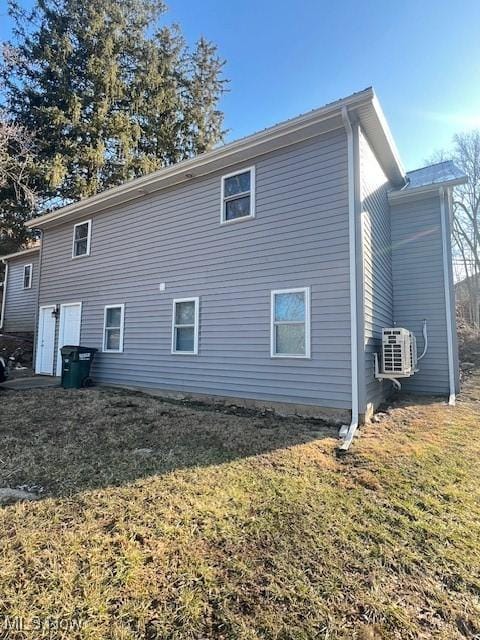 view of home's exterior featuring ac unit and a yard