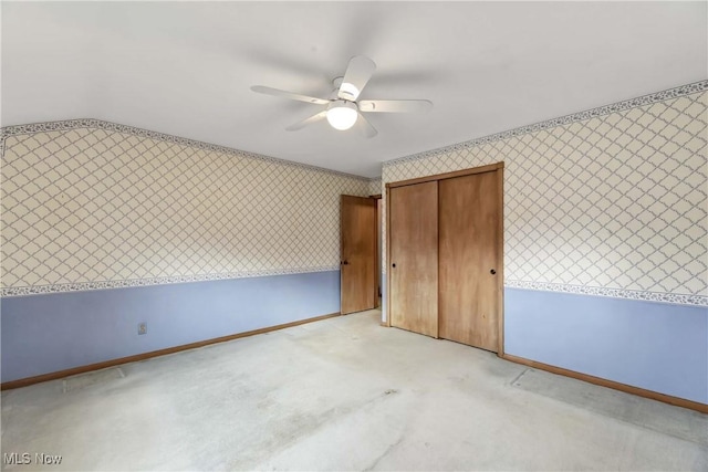 unfurnished bedroom with wallpapered walls, light colored carpet, baseboards, and a ceiling fan