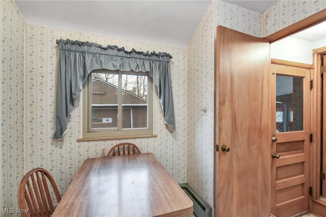 dining space featuring a baseboard radiator and wallpapered walls