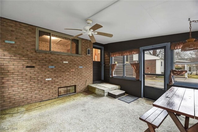 unfurnished sunroom with ceiling fan