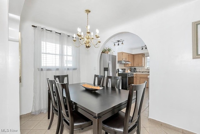 4707 Brookhigh Dr, Brooklyn, OH 44144 - dining room with arched walkways, light tile patterned floors, a notable chandelier, and baseboards