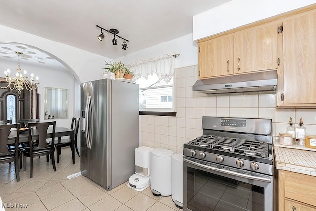 4707 Brookhigh Dr, Brooklyn, OH 44144 - kitchen featuring a notable chandelier, light tile patterned floors, under cabinet range hood, stainless steel appliances, and light brown cabinetry