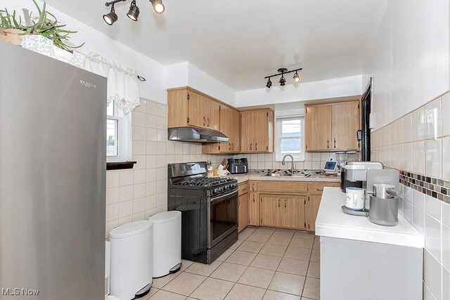 4707 Brookhigh Dr, Brooklyn, OH 44144 - kitchen with freestanding refrigerator, under cabinet range hood, light countertops, a sink, and black gas range