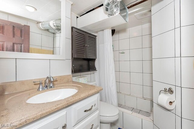 4707 Brookhigh Dr, Brooklyn, OH 44144 - full bath featuring tiled shower, tile walls, a sink, and toilet