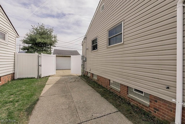 4707 Brookhigh Dr, Brooklyn, OH 44144 - view of property exterior featuring an outbuilding, concrete driveway, fence, and a gate