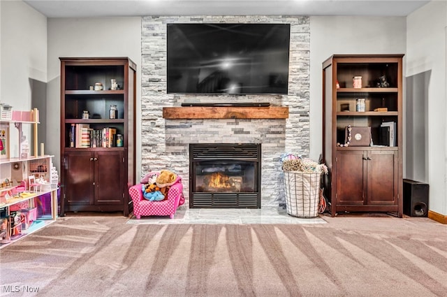 carpeted living room featuring a stone fireplace