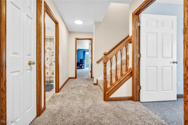 hall with stairway, carpet flooring, and baseboards