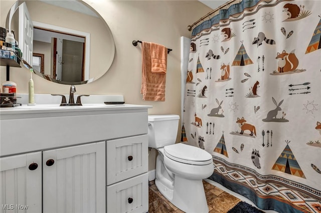 bathroom with toilet, vanity, and a shower with shower curtain