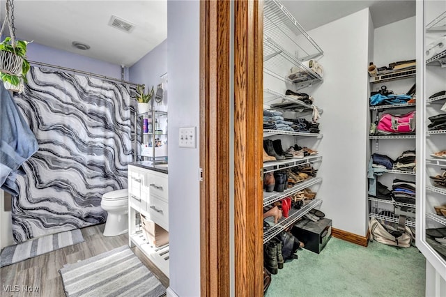 spacious closet featuring visible vents and wood finished floors