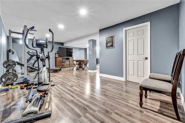 exercise area featuring recessed lighting, wood finished floors, and baseboards