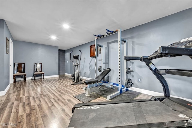 exercise area with recessed lighting, baseboards, and light wood finished floors