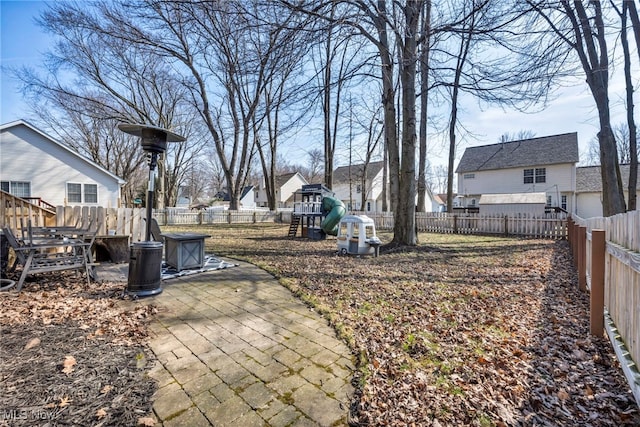 view of yard with a residential view, a patio, a fenced backyard, and a playground