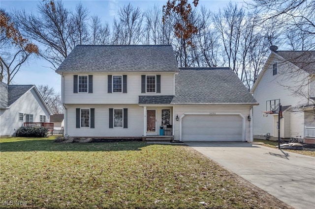 view of front of home featuring an attached garage, driveway, a front yard, and roof with shingles