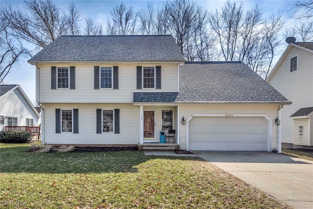 view of front of property with an attached garage, concrete driveway, a front yard, and roof with shingles